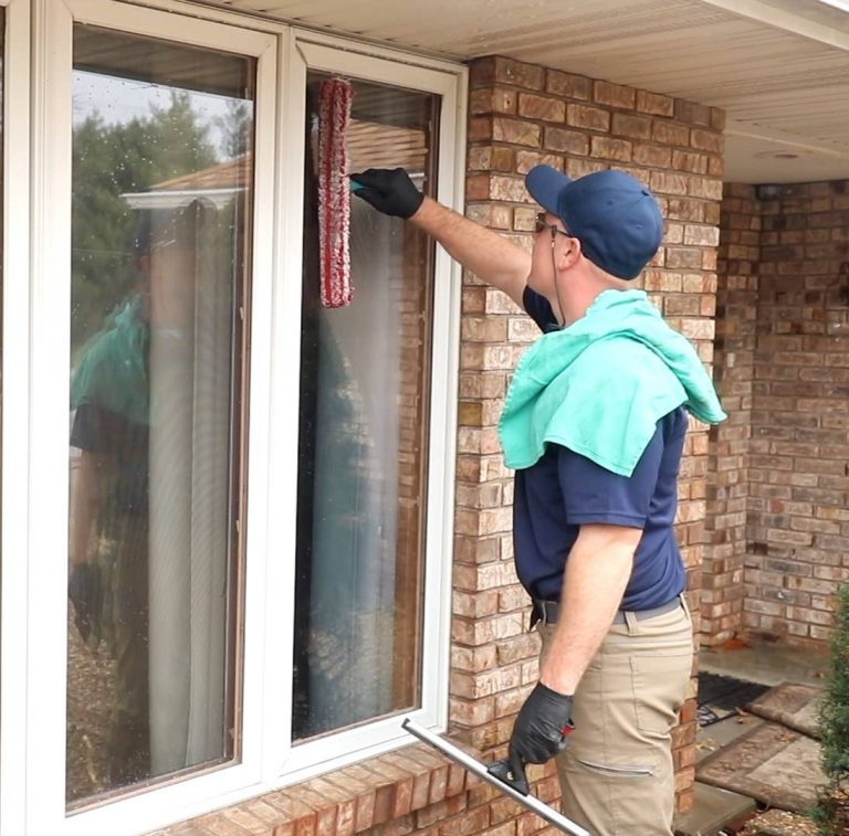 A Pressure Force employee cleaning a window